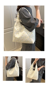 Detail of floral canvas tote bag with white lace bow and delicate yellow flower patterns
