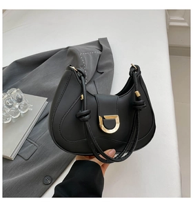 Detail der schwarzen Halbmond-Handtasche mit goldener D-Schnalle und Seil-Griff-Design