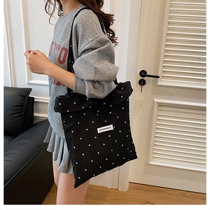 Détail du sac cabas noir à pois avec bord plissé et étiquette Fashion Bag en gros plan