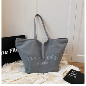 Gros plan détaillé du sac cabas en toile grise avec broderie blanche sur dentelle