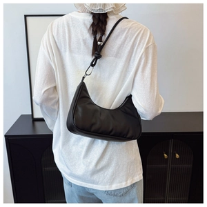 Detailed back view of a black crescent hobo bag with a zipper and silver buckle detail