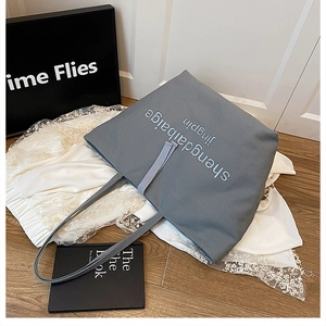 Détail du sac cabas gris en toile avec lettres brodées et anses solides et chic