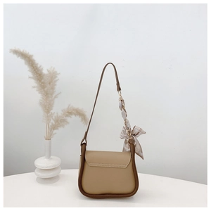 Back view of camel and brown crossbody bag featuring a striped silk scarf on the strap
