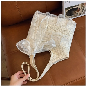 Detailed close-up of beige lace tote bag with intricate floral embroidery and bow detail