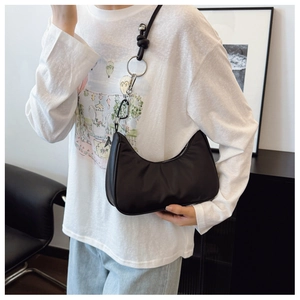 Chic black nylon crescent hobo bag with silver metallic hardware shown on shoulder