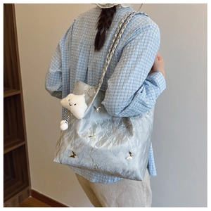 Silver metallic tote bag with butterfly buckles and plush cloud charm on a shoulder strap