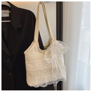 Close-up of white crochet lace tote bag featuring elegant bow and floral textures