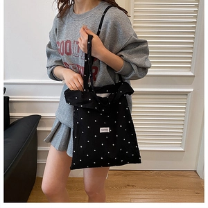 Détail du sac cabas noir à motif floral blanc avec étiquette Fashion Bag sur l'épaule