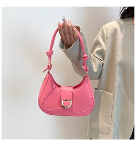 Détail du sac selle rose avec boucle dorée en D et bandoulière à nœud distinctive