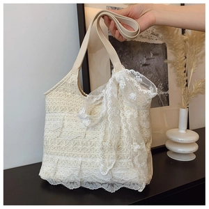Detail of cream lace tote bag with multilayer floral embroidery and a large bow