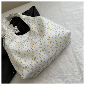 Detail of floral canvas tote with daisy prints and a delicate lace bow accent