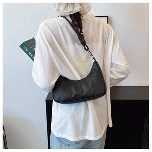 Minimalist black crescent shoulder bag shown on model for stylish casual daily wear