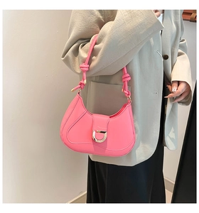 Detail of hot pink crescent bag with gold D-ring buckle and knotted shoulder strap detail