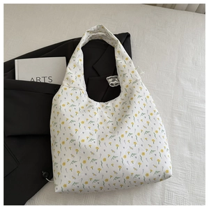 Detailed texture of beige floral canvas tote bag with yellow flowers and green leaves