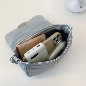 Sac à chaîne argenté métallisé montrant la capacité intérieure avec maquillage