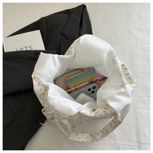 Detail view of floral canvas tote bag capacity with smartphone and daily essentials