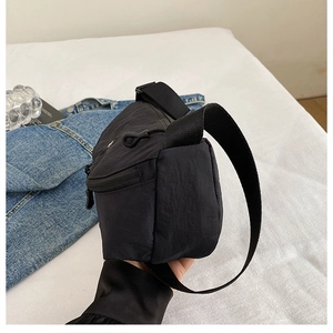 Detailed side view of black nylon crossbody bag showing matte texture and zipper closure