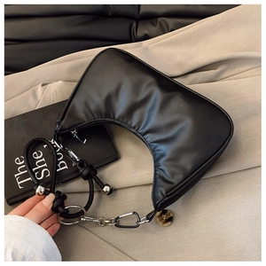 Detail of black crescent hobo bag featuring knotted rope strap and silver metal accents