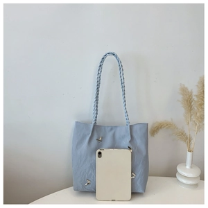 Light blue nylon tote bag with butterfly detail and woven handle showing large capacity