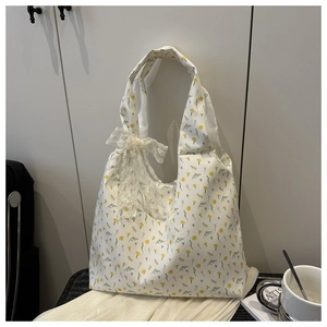 Detailed close-up of floral canvas tote bag with delicate lace bow and yellow flower pattern