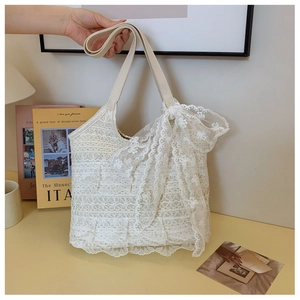 Close-up of white lace tote bag featuring detailed floral embroidery and a large bow