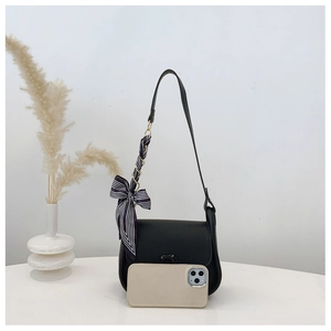 Detail of black leather crossbody bag with striped silk scarf and phone size reference