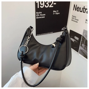 Detail of black faux leather half-moon shoulder bag with silver ring and knotted strap