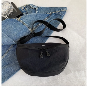 Detail of black crescent crossbody bag with double zippers and adjustable strap