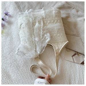 Close-up of white lace embroidery details on the summer beach tote bag with leather handles