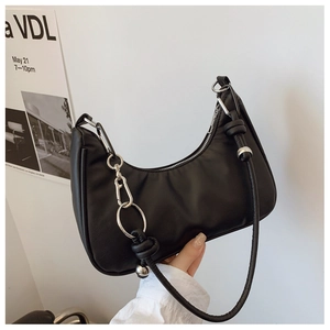 Detail of black leather hobo bag featuring silver ball hardware and knot strap design