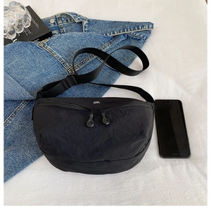 Detail of black crossbody bag with white ok embroidery and adjustable strap