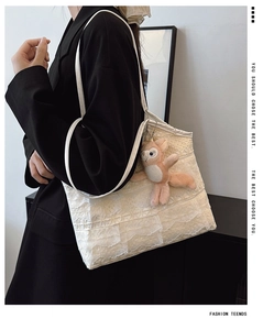 Detail der cremefarbenen Spitzen-Tote-Bag mit mehrlagigen Rüschen und rosa Plüsch-Fuchshänger