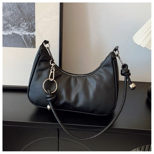 Detail of black leather dumpling bag with knotted strap and silver bead decorations