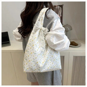 Detailed shot of yellow floral canvas tote with white lace bow on the side for students