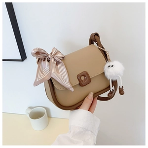 Detail of khaki crossbody bag with striped silk scarf and cute plush ball charm
