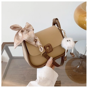 Detail of French style shoulder bag with striped silk scarf and white plush ball pendant