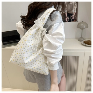 Detail of floral tote bag with lace edges and bow decoration on canvas fabric