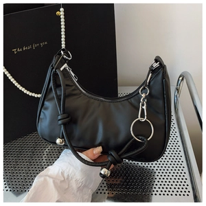 Dettaglio borsa hobo nera con pelle PU testurizzata, zip argento e tracolla di perle