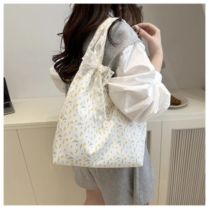 Detailed shot of floral canvas shoulder bag with a delicate white lace bow accent
