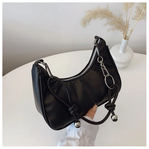 Détail du sac croissant en cuir noir avec poignée nouée et perles métalliques argentées