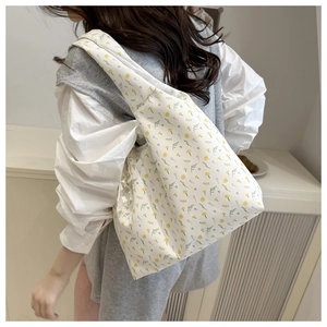 Floral canvas tote bag shown from a side-rear angle on model for a casual daily look