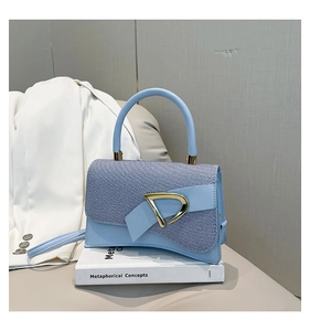 Detailed view of sky blue crossbody bag featuring woven texture and curved base design