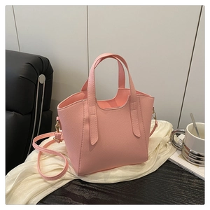 Dettaglio borsa a secchiello rosa in pelle martellata con bordo ondulato su seta