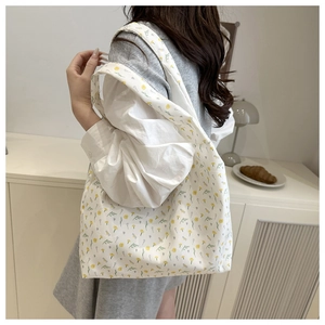 Close-up of floral canvas tote bag with yellow print showing textile texture and shoulder strap