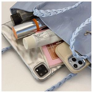 Macro shot showing internal space of light blue tote bag with woven handle and daily items