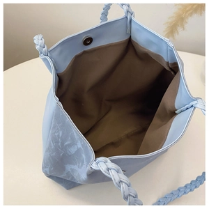 Detail of light blue marble tote bag with magnetic clasp and woven handle
