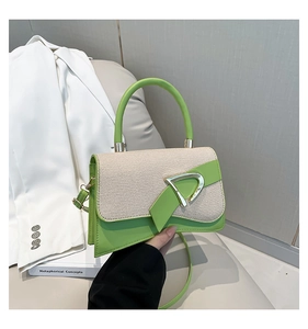 Detail of green leather and woven fabric crossbody bag with golden D-ring buckle