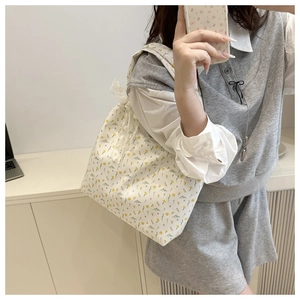 Close-up of floral canvas tote bag with yellow flowers and white lace bow detail