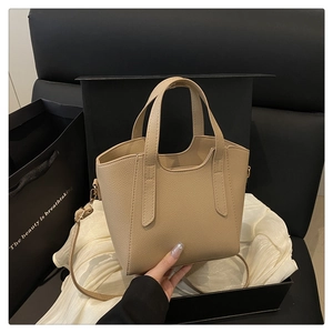 Dettaglio della borsa a secchiello beige con trama a grana in confezione regalo