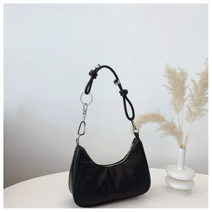 Detail of black crescent hobo bag featuring silver metal rings and knotted shoulder strap